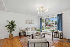 Living room featuring light wood-style floors and a chandelier