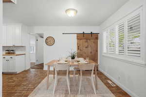 Dining area with a barn door and brick floors