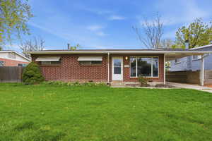 View of front of home featuring brick siding and a carport