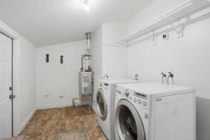 Laundry area with washing machine and dryer and water heater