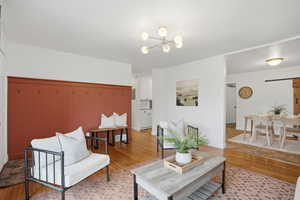 Living area with light wood finished floors and a chandelier