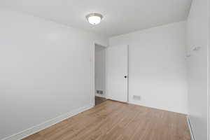 Bedroom 4 featuring light wood finished floors and baseboards