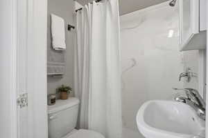 3/4  bath featuring a sink and a shower with shower curtain