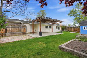 Back of house featuring a patio area, a pergola, a fenced backyard, and an outdoor structure