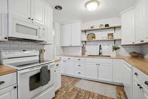 Kitchen with white appliances and white cabinetry