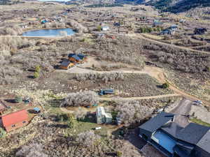 Aerial view of property and surrounding area with a nearby body of water