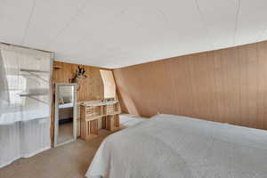 Bedroom featuring carpet floors and wood walls