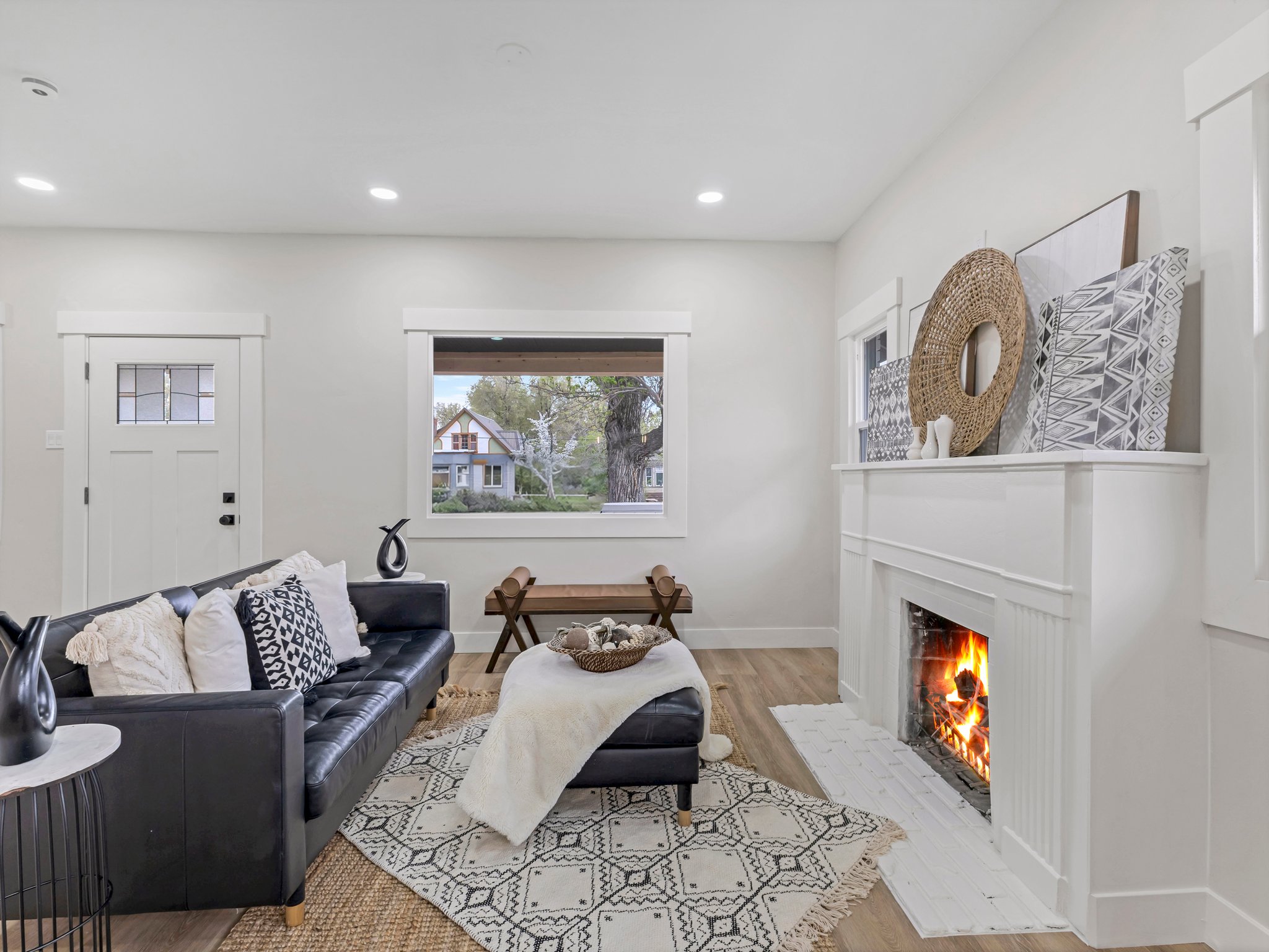 Living room with light wood finished floors, a fireplace with flush hearth, and recessed lighting