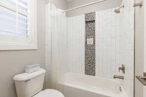 Bathroom featuring toilet and shower / bath combo