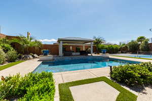 View of pool featuring a fenced backyard and patio surround