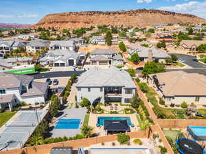 Aerial perspective of suburban area featuring a mountainous background and a pool area
