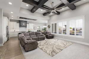 Living area with ceiling fan, coffered ceiling, and recessed lighting