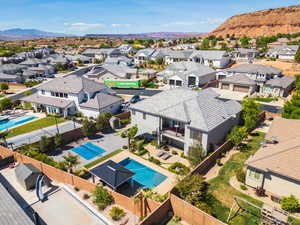 Aerial perspective of suburban area featuring a pool and mountains