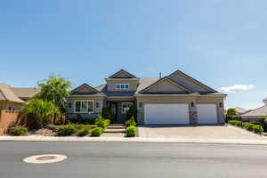 Craftsman inspired home with an attached garage, stone siding, stucco siding, and concrete driveway