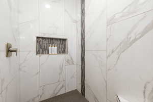 Bathroom featuring a marble finish shower