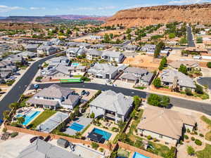 Aerial view of property and surrounding area featuring mountains and nearby suburban area