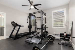 Exercise room with ceiling fan and baseboards