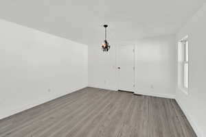 Unfurnished dining area featuring light wood-type flooring and baseboards