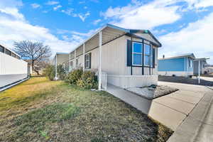 View of side of home featuring a yard
