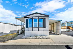 Manufactured / mobile home with concrete driveway and an attached carport