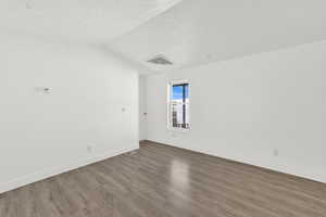Empty room featuring dark wood finished floors and baseboards