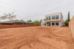 Rear view of house featuring a fenced backyard, a patio area, stucco siding, and a balcony