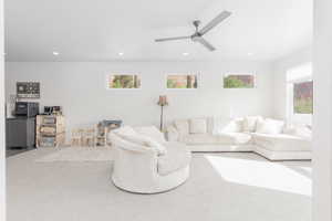 Living area featuring carpet flooring, recessed lighting, and a ceiling fan