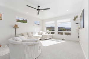 Living area featuring carpet, healthy amount of natural light, a ceiling fan, and recessed lighting