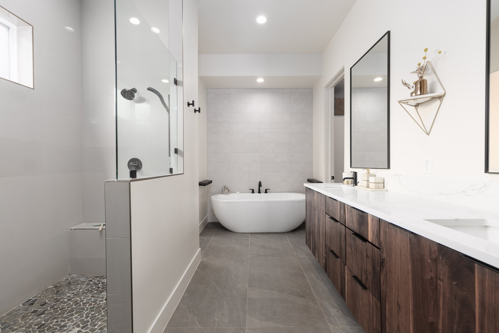 Full bathroom with a walk in shower, double vanity, a freestanding bath, recessed lighting, and tile walls