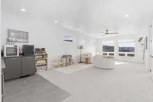Living area with light carpet, light tile patterned floors, recessed lighting, and ceiling fan