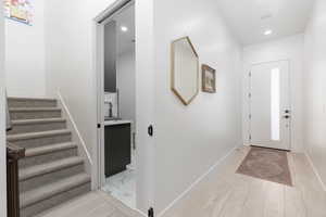 Entrance foyer with light wood-style flooring and recessed lighting