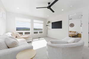 Living area with light carpet, recessed lighting, and ceiling fan