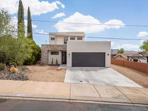 Contemporary house with stucco siding, concrete driveway, and an attached garage