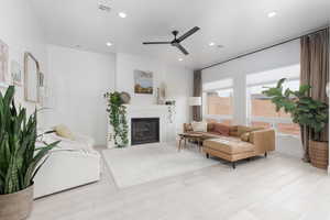 Living room with ceiling fan, recessed lighting, light wood-style flooring, and a fireplace