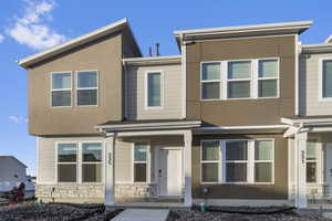 View of front of house with stucco siding, stone siding, and a porch