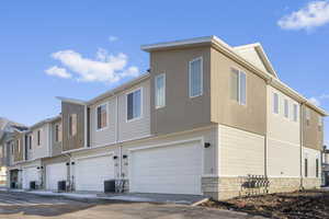 Rear view of property with an attached garage, stone siding, and a residential view