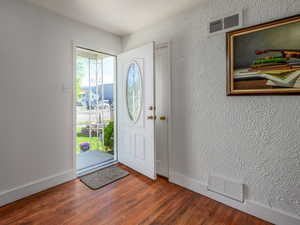 Entryway featuring a textured wall and dark wood-type flooring