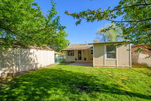 Back of property with a fenced backyard, a patio, and a chimney