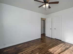 Unfurnished bedroom featuring dark wood finished floors and ceiling fan