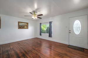Entrance foyer with dark wood-style flooring and a ceiling fan