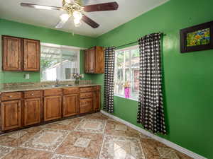 Kitchen with wood finish cabinets, ceiling fan, and black range oven