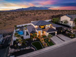 View of front of home with driveway, an attached garage, a fenced backyard, stucco siding, and a mountain view