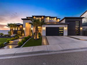 View of front of house featuring driveway, an attached garage, a standing seam roof, a front lawn, and brick siding