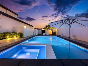 Integrated pool / hot tub featuring a fenced backyard