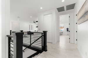 Hall featuring an upstairs landing, recessed lighting, and light marble finish flooring