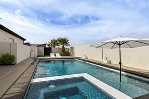 Integrated pool / spa featuring a fenced backyard and a patio area