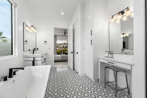 Ensuite bathroom featuring vanity, a freestanding bath, recessed lighting, and a ceiling fan