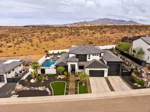 View of front of property with a garage, concrete driveway, a desert view, and a mountain view