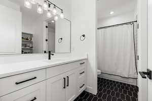 Bathroom with vanity, shower / tub combo, and recessed lighting