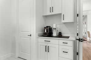 Bar area with white cabinets and light countertops